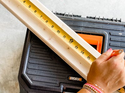 measuring tape on top of wood piece and stool