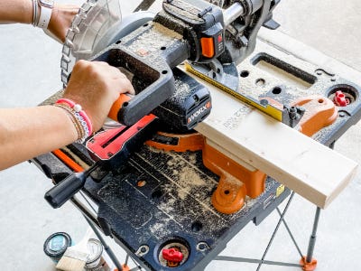 miter saw cutting wood piece on top of worx work table