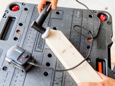 using angle grinder to sand down tip of wood piece