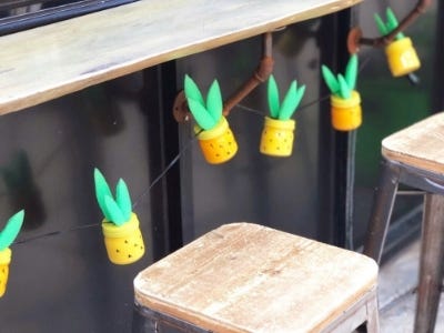 pineapple jars hanging underneath table on string behind a bar stool