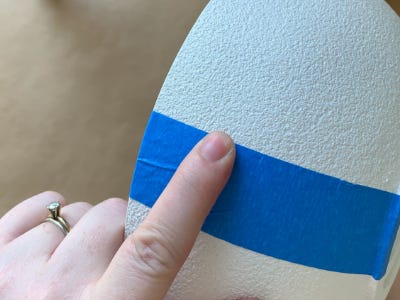 pressing blue tape on to white pot