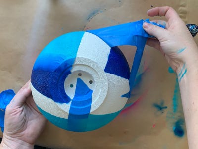 removing blue masking tape on white pot