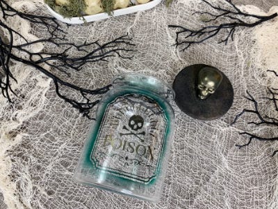 poison glass on back facing up next to skeleton head cap