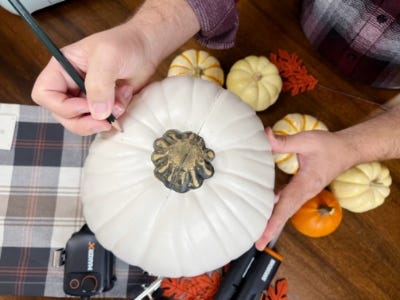 using pencil to sketch on white pumpkin