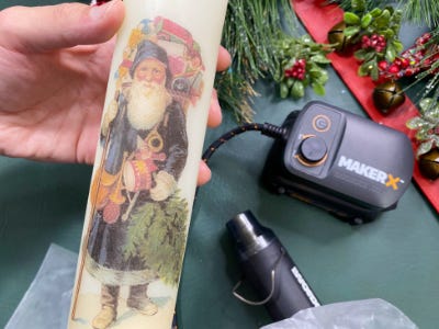 holding santa candle in front of heat gun and battery and charger