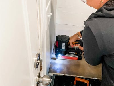 using nail gun to attach shelf to wall