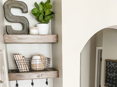 wooden stain shelves with plant pots and basket with books in it