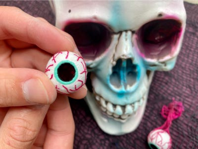 holding eye ball in front of skull