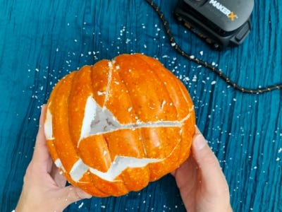 using rotary tool to cut cracks in the side of the pumpkin