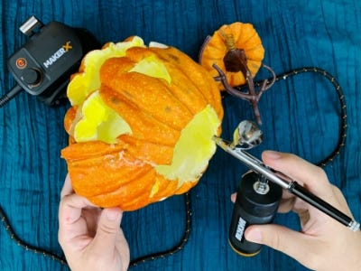 spray painting the top of the pumpkin on its side