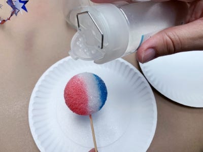 covering the red, white and blue foam ball with glitter