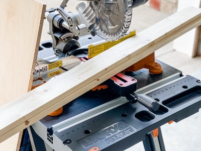 two wood pieces sitting on worktable with cutting saw