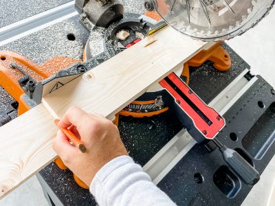 lining up the wood board to cut with saw