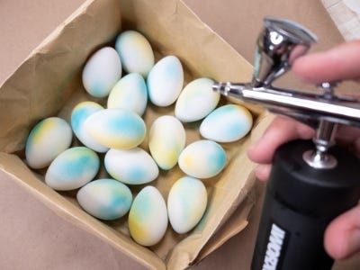 eggs in a box with someone adding color to them with the worx makerx air brush