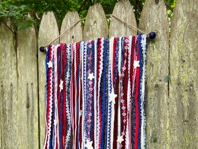 Fabric wooven cloth with stars on it hanging from wooden fence 