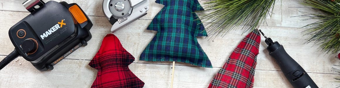 Three plush flannel Christmas trees next to tools