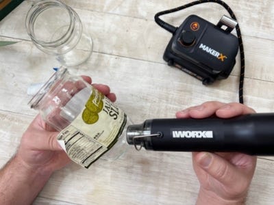 heat gun being used on jar to remove jars label