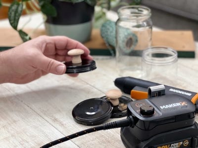 holding jar lid that has wooden handle attached to it