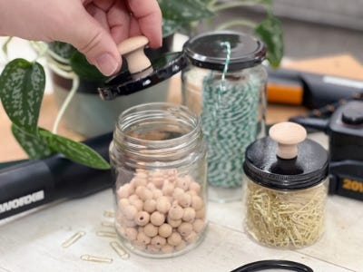 one open jar next to smaller two jars filled next to scissors and batter charger