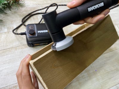 angle grinder sanding down edges of wood box