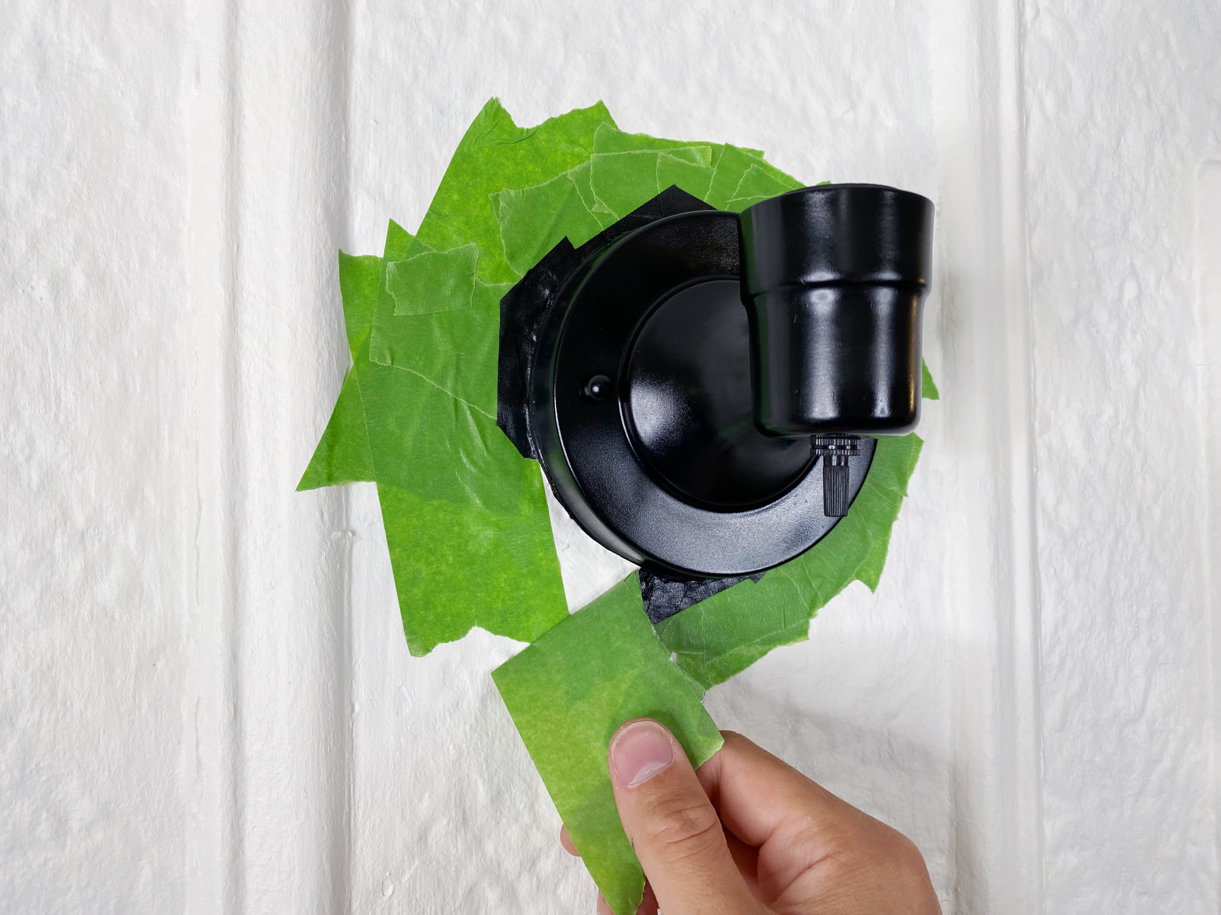 removing of green painters paint around black sconce