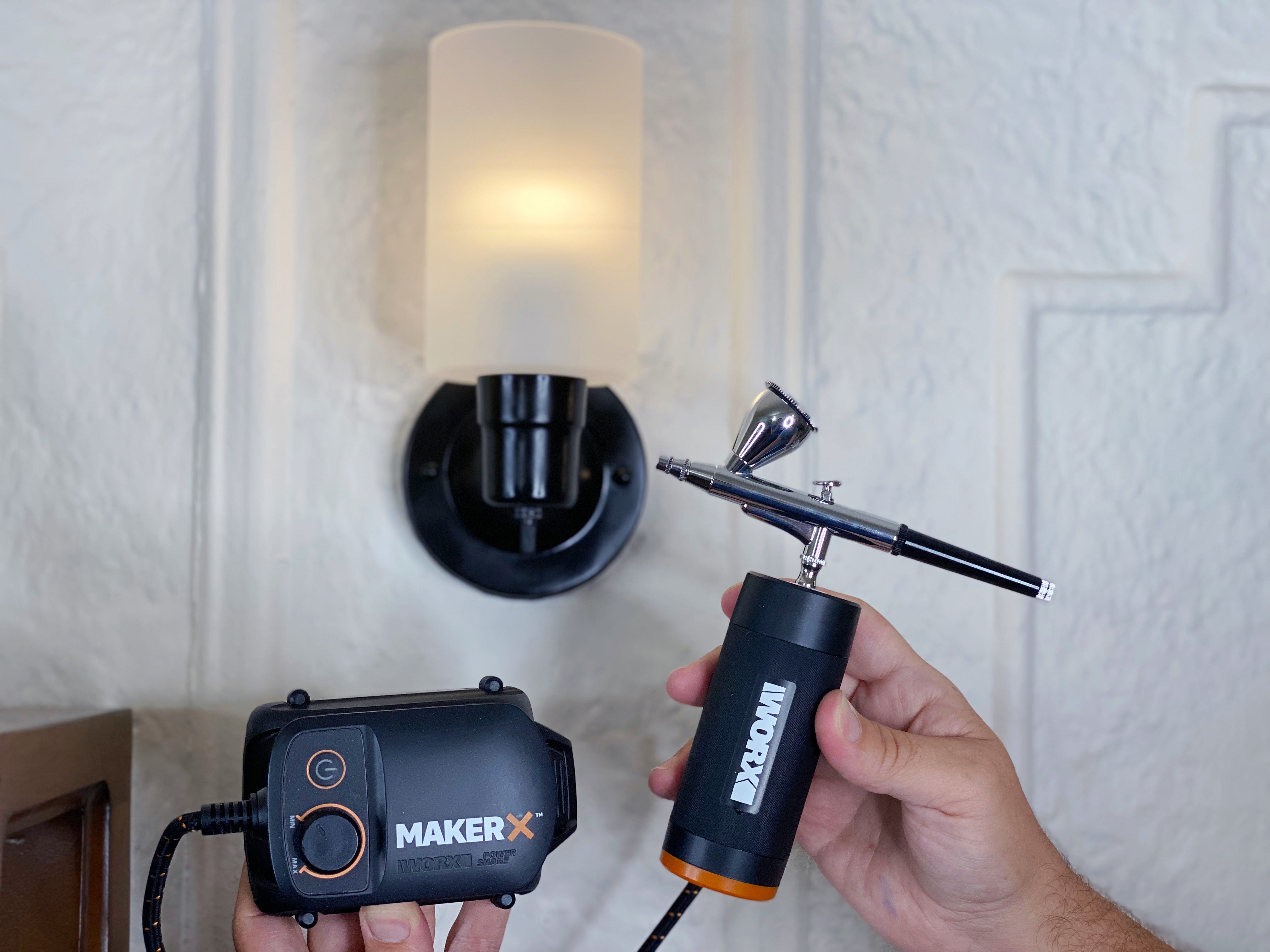 holding up worx air brush in front of black painted sconce