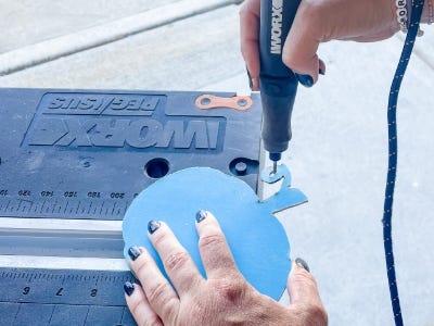 using the drill rotary tool to drill hole into stem of wood pumpkin