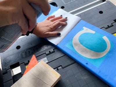 spray painting stencil letters with black paint