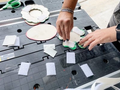 cutting tape to apply to back of four leaf clover piece