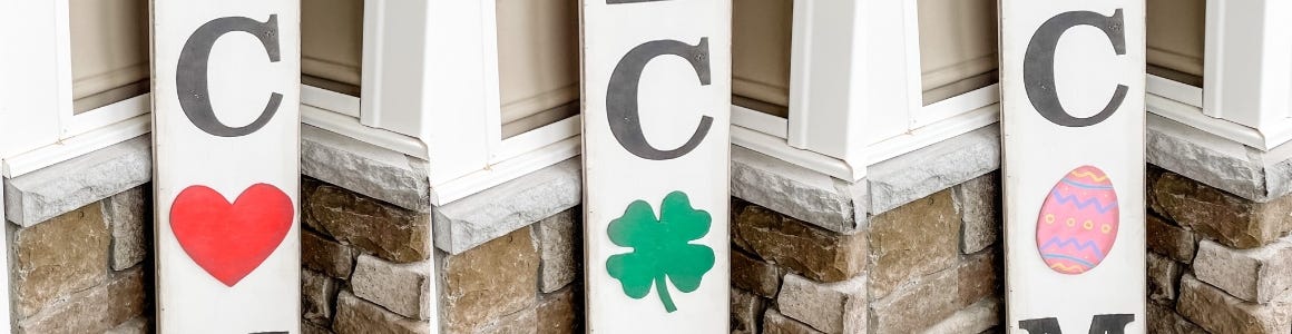 three different examples of welcome signs using a heard, four leaf clover, and egg ad the O