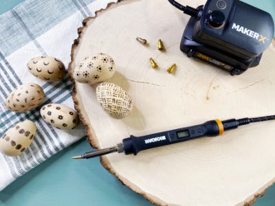 Lots of little eggs with very orientated wood burned design patterns into them next to Rotary tool 