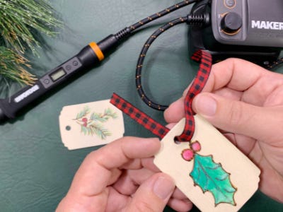 Threading ribbon through the whole of wood burned piece with green leaf and red berry