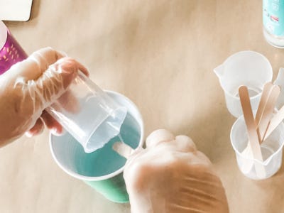 in a green cup the resin is being poured and mixed