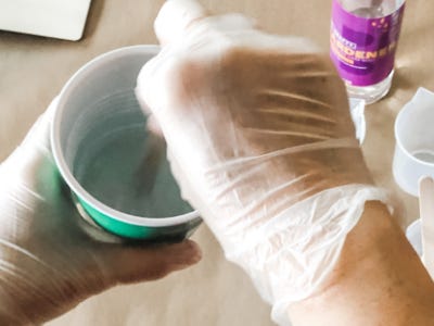 green color resin is being stirred in cup