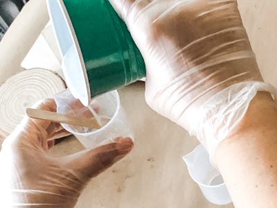 Pouring resin from bigger solo cup into smaller measuring cup