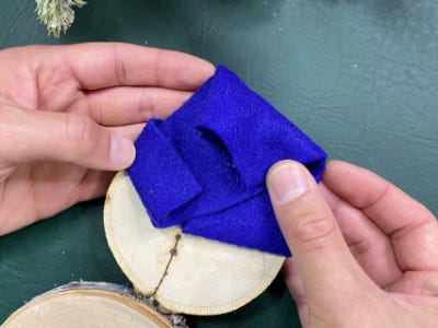 placing blue felt fabric above white snowman ornament