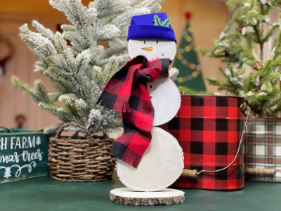 snowman wood ornament with blue hat and red and black scarf