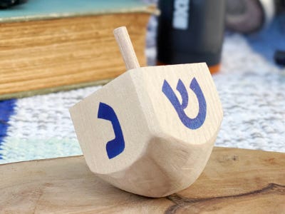 wooden dreidel with blue paint sitting on table