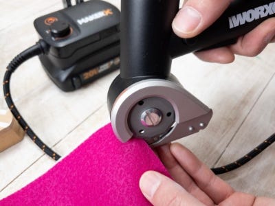 using worx zipsnip to cut into pink cloth