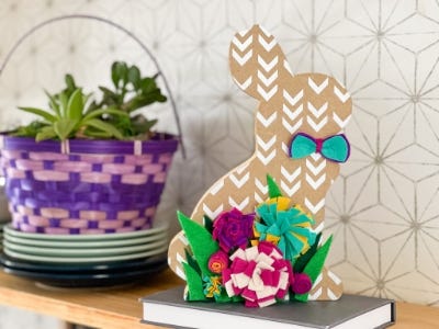 wooden bunny with flowers and boy tie sitting book and table