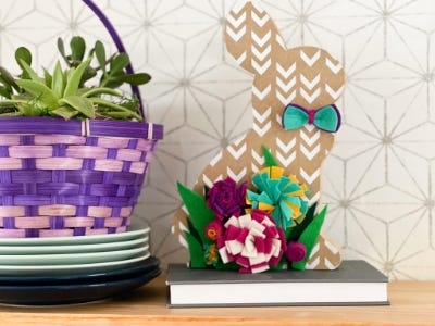 wooden bunny with flowers and boy tie sitting book and table from the side