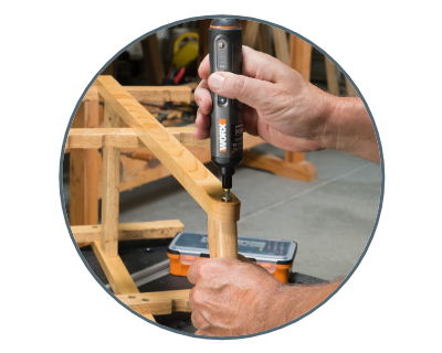 close up of a person using  the screwdriver on a piece of wood