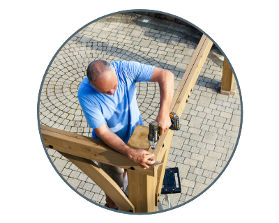 man using the drill to connect wooden beams