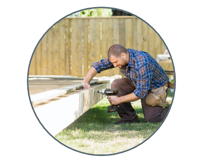 man using the drill to build a wooden deck