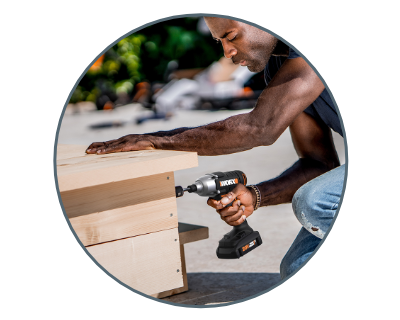 man using the drill to build a wooden platform