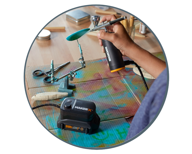 image of a woman using the air brush to paint a wooden handle