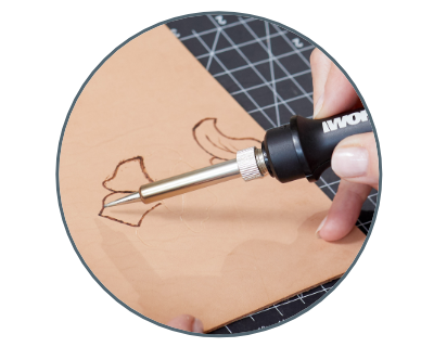 close up image of a person using the crafter to burn a flower onto a piece of wood