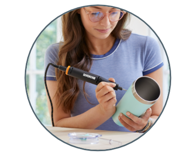 woman using the rotary tool to engrave a cup