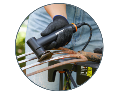 person using the angle grinder to remove rust from a pitchfork