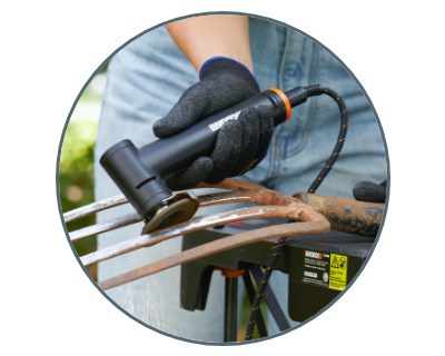 person using the angle grinder to remove rust from a pitchfork